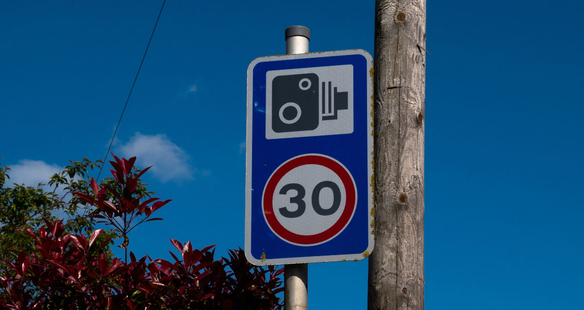A speed limit sign and a speed camera sign