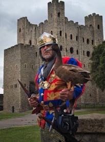 Mark dressed as King John with his duck standing in front of a castle